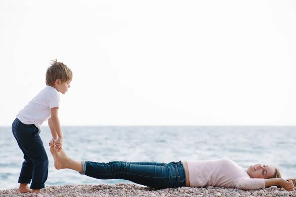 Divertente Attivo Piccolo Ragazzo Sollevamento Sua Madre Sdraiato Sul Mare — Foto Stock