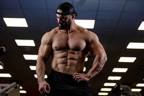 ブルーライトスポーツジムで完璧な腹部の筋肉を持つ強い若い髭の男 — ストック写真