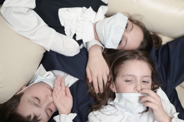 Coronavirus covid-19 salgını. Karantina salgını. Üç küçük çocuk ailesi okul üniforması ve sağlık maskesi takıyor.