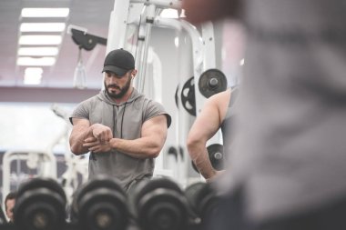 Spor sakatlığı konsepti. Sakallı, genç ve güçlü bir erkek. Acı veren bileğini tutuyor.