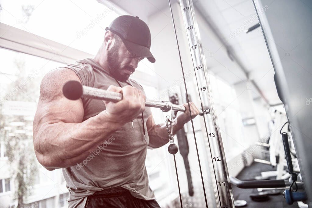 sport motivation concept of powerful focus man training his biceps muscles in sport gym