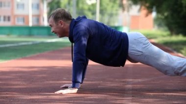Açık bir stadyumda egzersiz yapan erkek. Sabah jimnastiği.