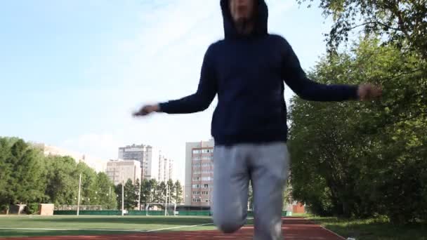 Hombre haciendo ejercicio en un estadio al aire libre. Gimnasia matutina . — Vídeos de Stock