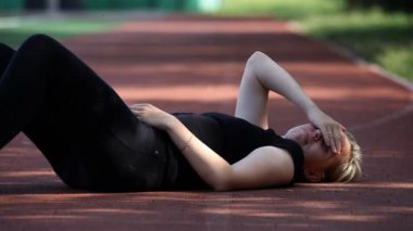 yorgun kız yerde Stadı nda jogging sonra dinlenme