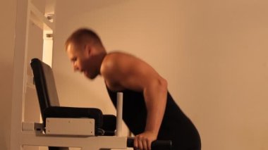 Kaslı vücut geliştirmeci adam egzersizleri yapıyor.