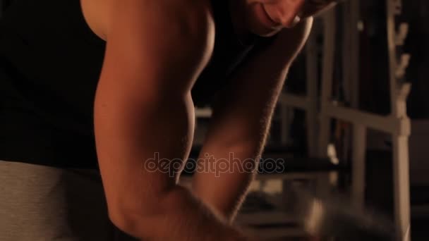 Kaslı vücut geliştirmeci adam spor salonunda dumbbells ile yapıyor — Stok video