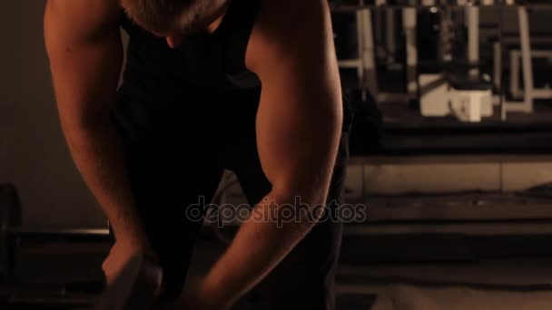 Kulturysta muskularny facet robi ćwiczenia z hantlami w siłowni — Wideo stockowe