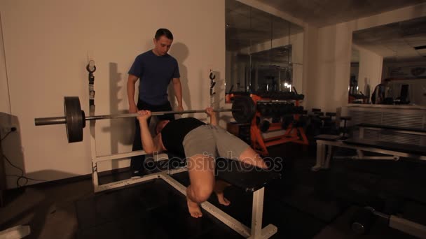 Muscular bodybuilder guy doing exercises. raises the bar. — Stock Video