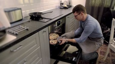 gözlüklü adam fırın pizza koyar