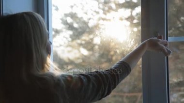 Bir kadın bir pencere ve nefes temiz soğuk hava açar