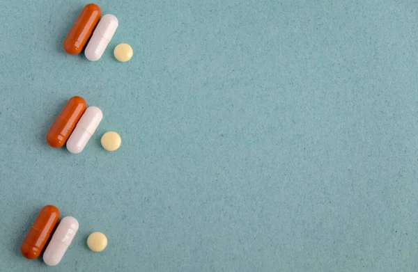 Brown and white pill capsules on a blue background. Disease prevention. copy space Royaltyfria Stockfoton