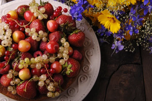 Fruit cake and flowers. — Stock Photo, Image