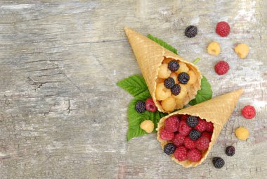 Ahududu kırmızı, sarı ve siyah gri bir ahşap zemin üzerinde gözleme bardak.