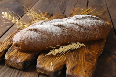 Kepekli ekmek ve bir ahşap arka plan kulaklara.