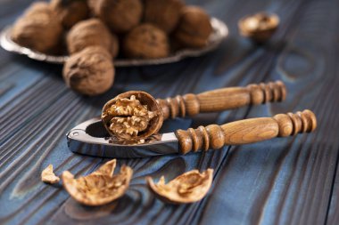 Mavi ahşap arka planda klasik ceviz kıracağı ve ceviz..