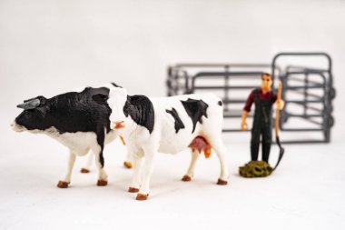 Oyuncak çiftliği. Minyatür plastik inekler ve bir işçi.