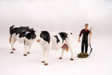 Oyuncak çiftliği. Minyatür plastik inekler ve bir işçi.