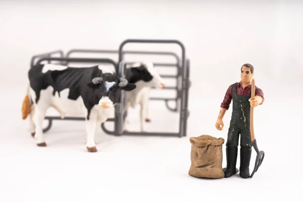 Toy farm. Miniature plastic cows and a worker.