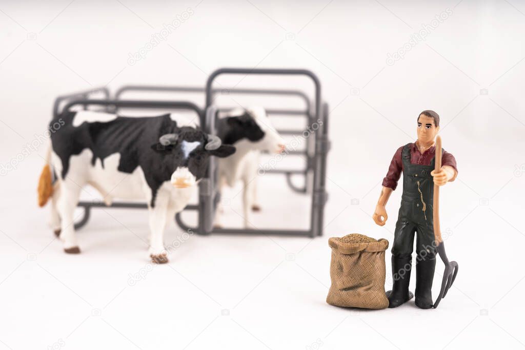 Toy farm. Miniature plastic cows and a worker.