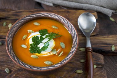Kil kasede balkabağı çorbası, kaşık, bütün balkabağı ve çuval bezi..