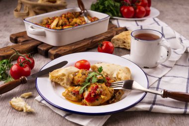 Mavi kenarlı beyaz tabakta sebzeli tavuk güveci. Yemek masası. Gürcistan mutfağı - Chakhokhbili.