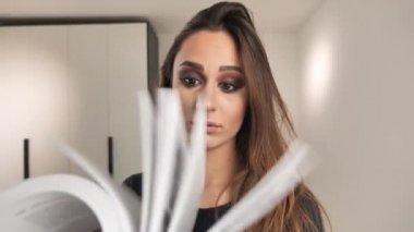 Kız akıcı bir şekilde kalın bir kitaba bakıyor ve 4K 'da kayboluyor.