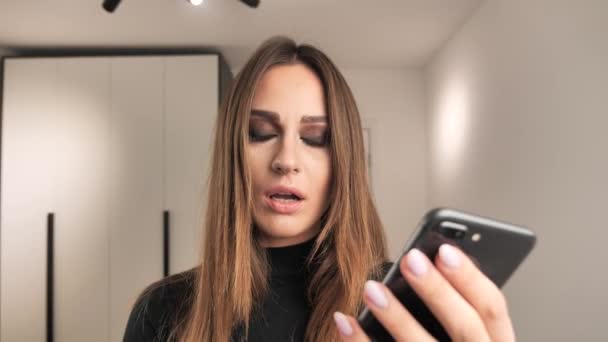 La chica habla lindo en el teléfono y descubre información horrible su cara expresa miedo y desconcierto. 4k — Vídeos de Stock