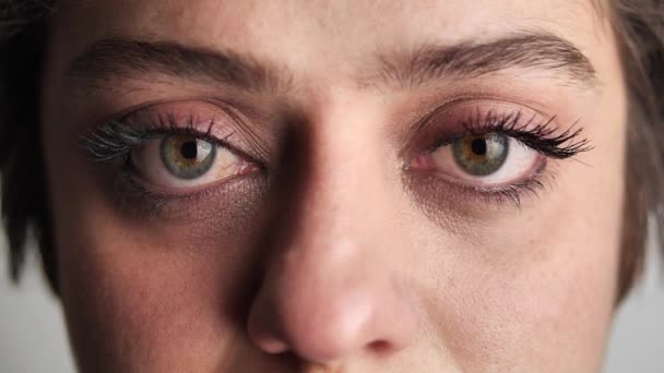 Een close-up portret van schoonheid jonge mooie vrouwen ogen, glimlachend kijkend naar de camera. Grijze ogen van een vrouw gezicht, mooie vrouw meisje portret model, de meisjes oog. openen van haar grijze ogen — Stockvideo