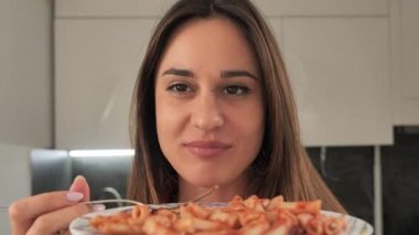 Genç mutlu kadın makarnanın tadını çıkarıyor.