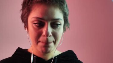 Stres yaşayan bir kızın portresi. Büzüşmüş dudaklar ve neon arka planda ağız. Jest psikolojisi konsepti 4k