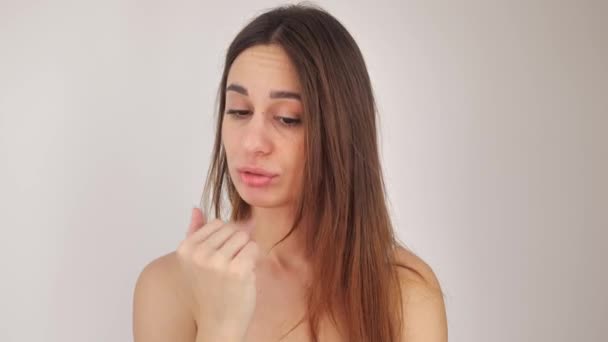 Ragazza sexy guardando in macchina fotografica su sfondo bianco. Giovane donna toccare le labbra con il dito 4k — Video Stock