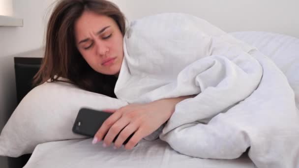 Dormiglione donna bruna svegliarsi a letto la mattina e non vuole alzarsi dal letto. Non un buon giorno. 4k — Video Stock