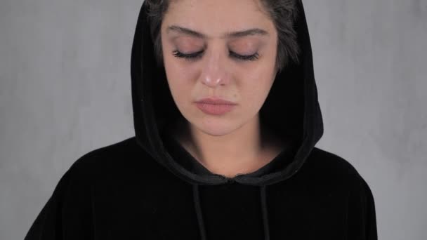 Unhappy pregnant teenager short-haired in a black hoodie with positive birth control test. 4k — Stock Video