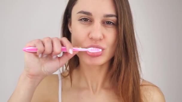 Молодая женщина чистить зубы в ванной комнате и остановиться из-за зубной боли 4k — стоковое видео