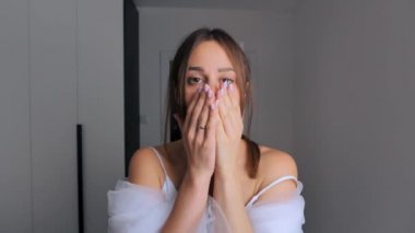 Gelinlik ve peçeli bir gelin portresi. Gelin evde giyiniyor. Mutlu gelin