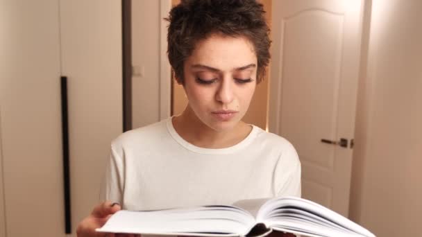 Un adolescente se prepara para un examen lee un libro 4k — Vídeos de Stock