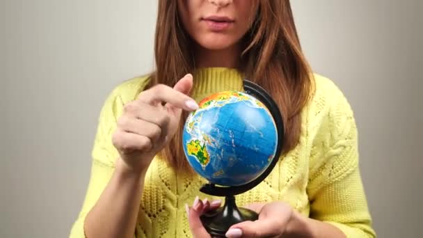 Жінка перевертає маленький глобус в руках. Концепція подорожей. 4k — стокове відео