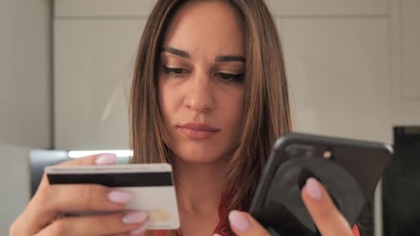 Meisje maken een online aankoop met succes via de telefoon door het invoeren van debetkaart nummers 4k — Stockvideo