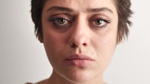 Portrét dívky s krátkými tmavými vlasy, velké oči, smutný pohled na bílém pozadí 4k — Stock video