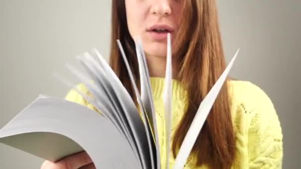 Genç ve çekici bir bayan öğrenci kitap okuyor. 4K metnini hatırlamaya çalışıyor. — Stok video