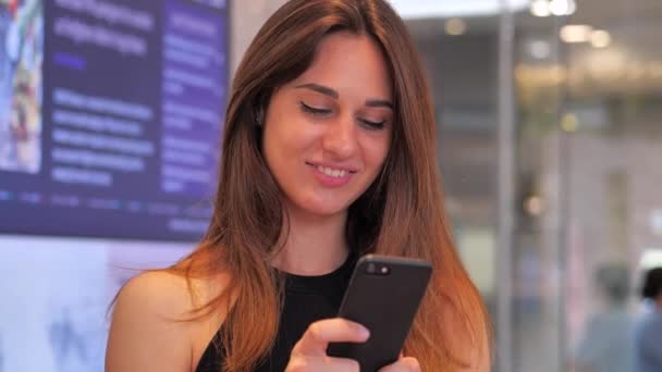 Дівчина в торговому центрі клацає на телефон столу з діаграмою на фоні 4k — стокове відео