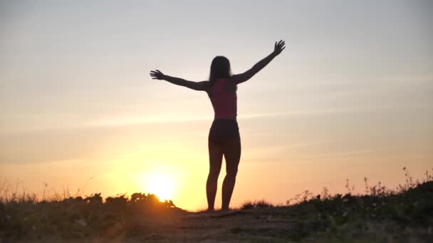 Mujer feliz saltando en la playa disfrutando de la puesta de sol en vacaciones de vacaciones de verano. Vídeo concepto felicidad y dicha con saltos femeninos de alegría celebrando en silueta. MOCIÓN LENTA 4k — Vídeo de stock