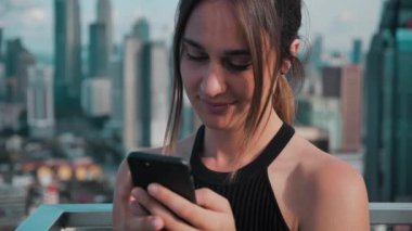 Gökdelenlerin arka planında telefonla konuşan çok meşgul bir kız. 4k
