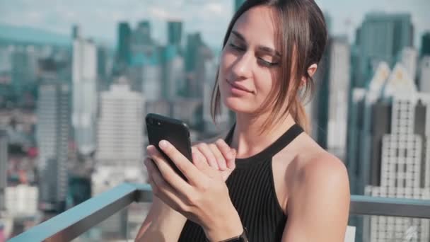 Деловая занятая девушка разговаривает по телефону на фоне небоскребов. 4k — стоковое видео
