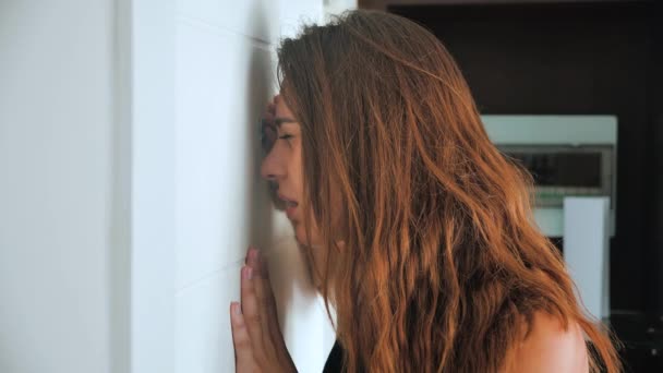 Paranoid woman is shocked looking into the peephole. The female wants to hide from an unexpected guest and shows shh. 4k — Stock Video