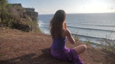 Beautiful and healthy female breathing gently and sits in pose of lotus or sukhasna meditating or practicing yoga and pranayama