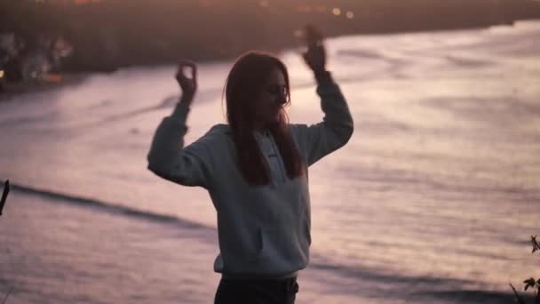 Primer plano retrato de una hermosa joven mirando hacia arriba explorando mindfulness contemplando la espiritualidad con el viento soplando pelo disfrutando de la tranquila playa al atardecer 4k — Vídeo de stock