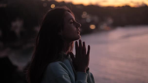 Közeli portré gyönyörű nő élvezi a békés naplemente felfedező spiritualitás felnéz imádkozó szemlélődő utazás szél fúj haj 4k — Stock videók