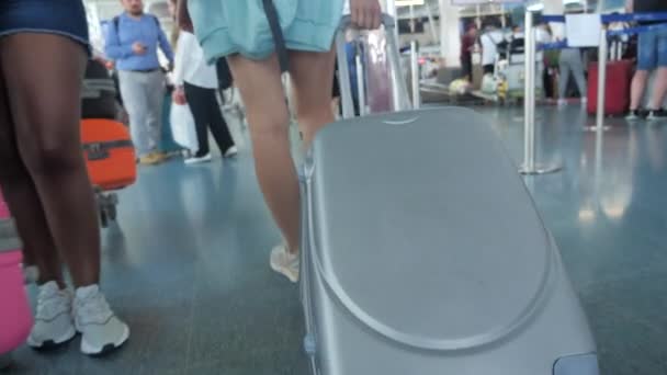 Mulher pisando e rolar mala sobre rodas. Mulher caminhando com sua mala ao longo do aeroporto. Conceito de viagem. Movimento lento 4k — Vídeo de Stock