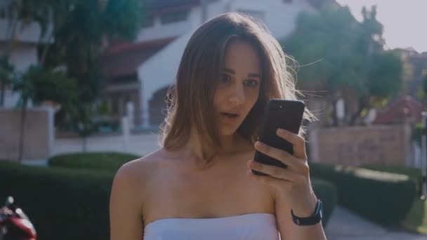 Retrato de una joven conmocionada usando un teléfono móvil. HD Time Lapse Emoción de vídeo. 4k — Vídeo de stock